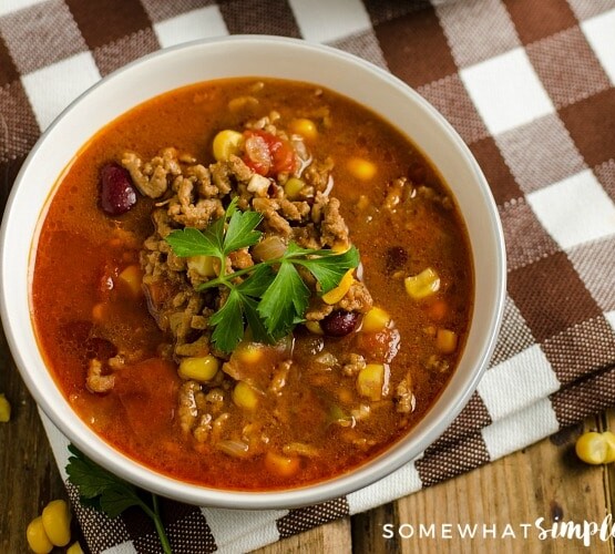 looking down on a bowl of taco soup topped with garnish