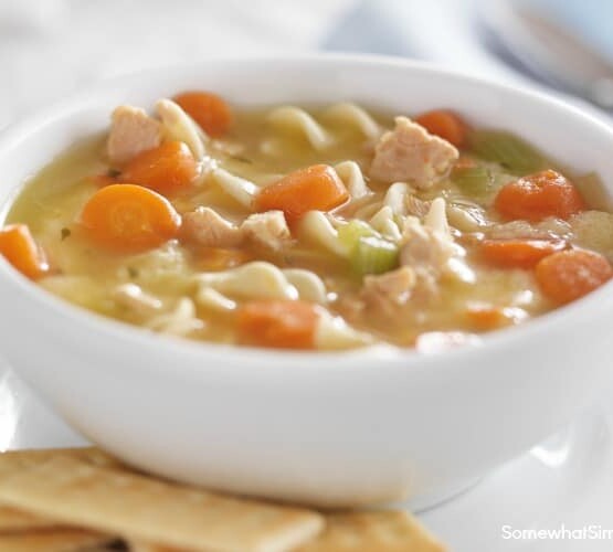 bowl of chicken noodle soup on white table cloth