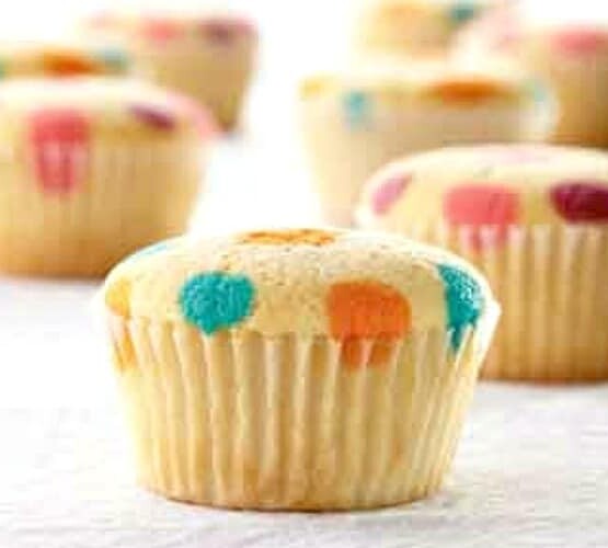 vanilla cupcakes with orange blue yellow red and purple polka dots