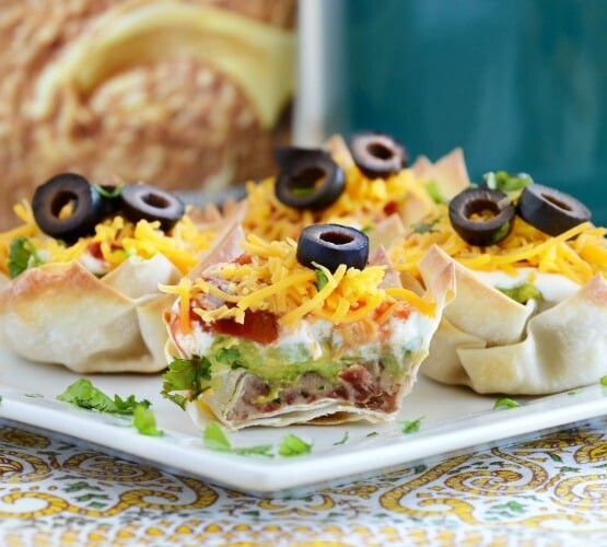 seven layer dip cups on a plate