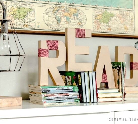 yarn wrapped letters on a book shelf that spell out the word read