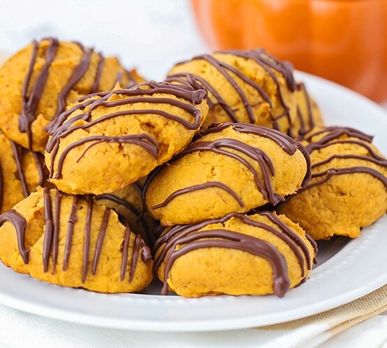 a plate full of chocolate glazed pumpkin cookies