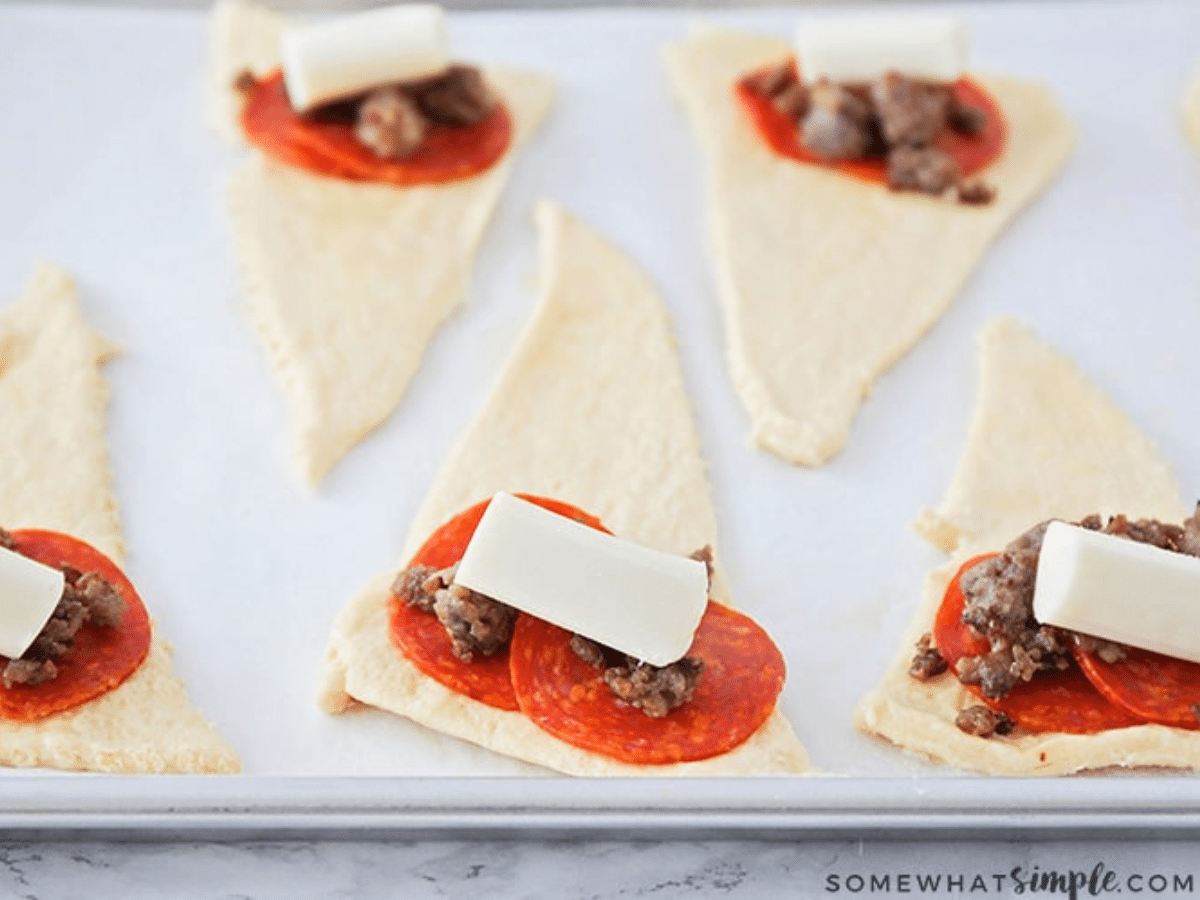 showing how to assemble pizza bites with crescent dough, meat and cheese
