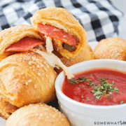 close up of pizza rolls plated with some dipping sauce