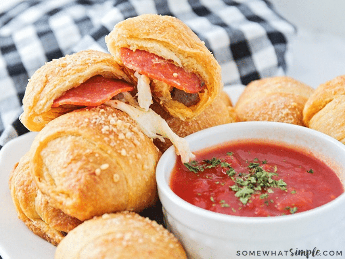 close up of pizza rolls plated with some dipping sauce