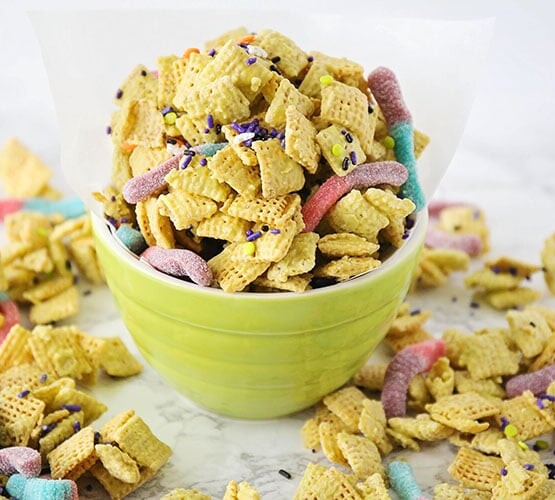 a bowl of zombie bait chex mix with sour gummy worms