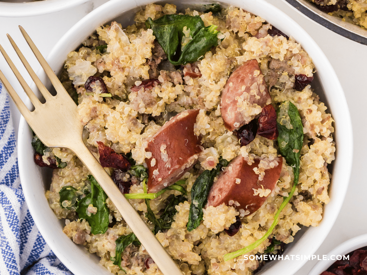 finished product of Sausage and Kale Quinoa in a white dish with gold fork