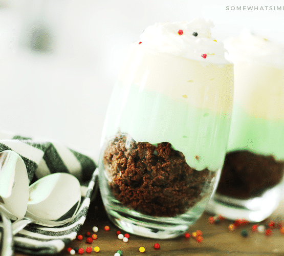 two pistachio parfait cups made with pistachio and vanilla pudding and brownie crumbles are a fun way to celebrate St Patrick's Day