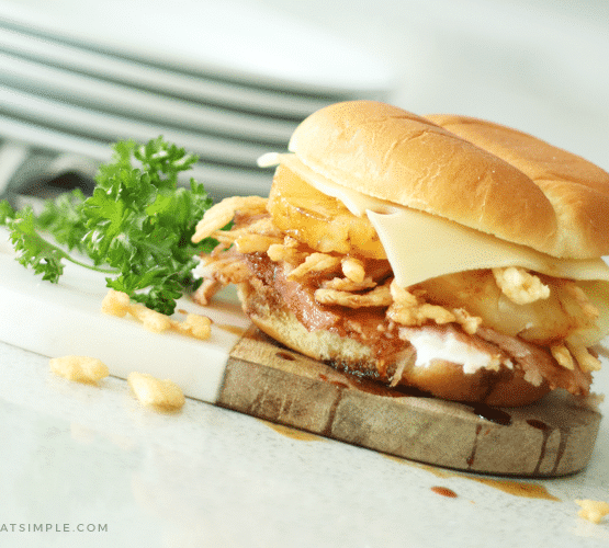 a Hawaiian ham sandwich filled with baked ham, fried onion strips, a slice of pineapple, teriyaki sauce and a slice of Swiss cheese.