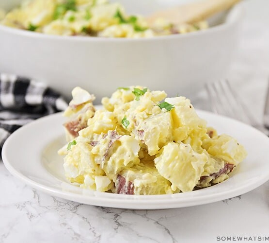 a plate with a serving of potato salad made with mustard and hard boiled eggs.