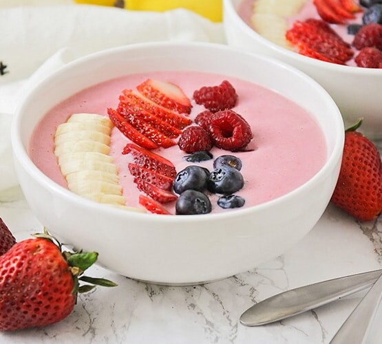 a smoothie bowl topped with sliced fresh fruit