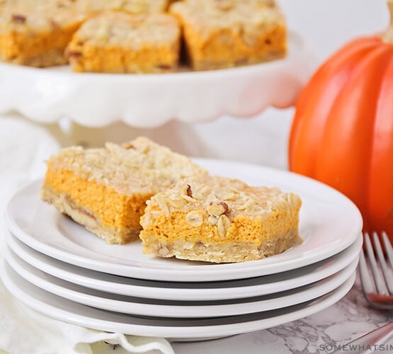 two squares of pumpkin pie bars on a stack of plates