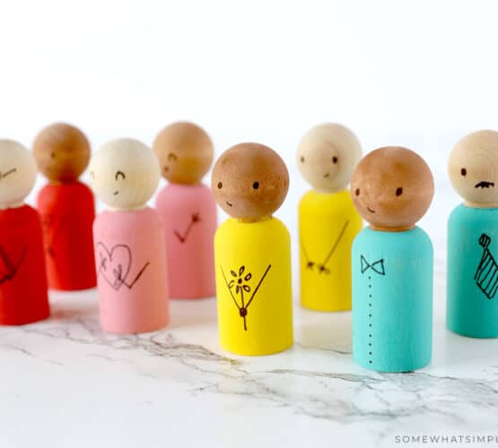 wooden spool dolls lined up on a counter