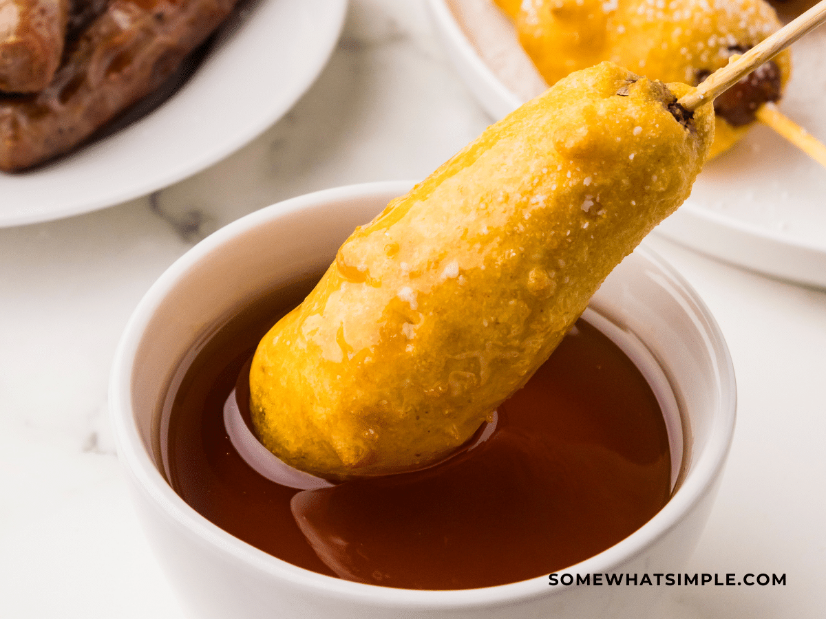 Breakfast Corndog being dipped in syrup